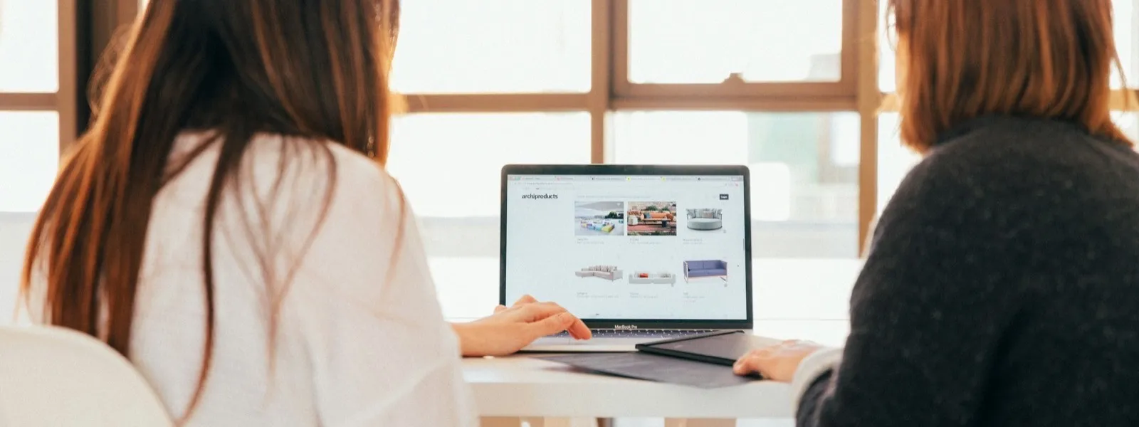 Deux personnes examinant ensemble une page web sur un ordinateur portable