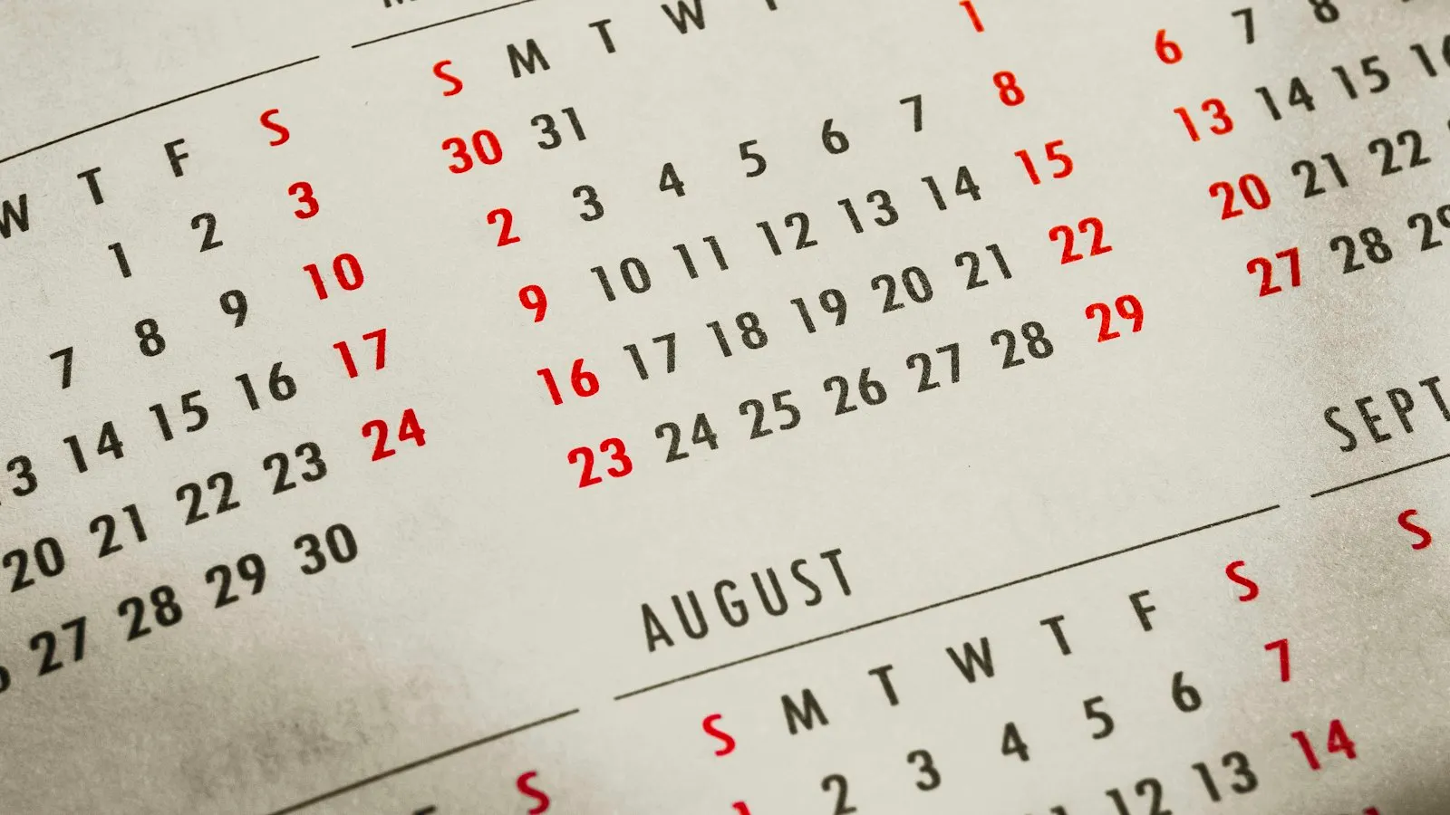Gros plan sur un calendrier mural ouvert, montrant plusieurs mois consécutifs